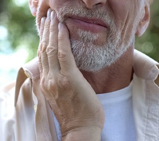 Close up of man rubbing his jaw