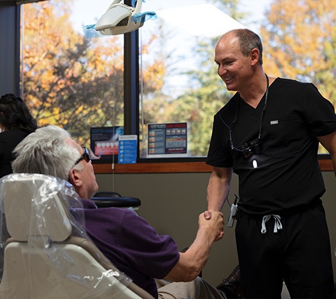 Dentist shaking hands with patient