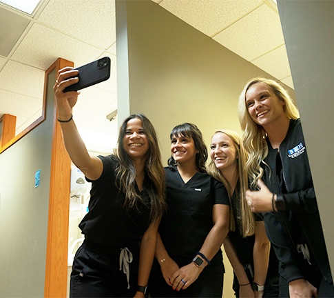 Four smiling dental team members