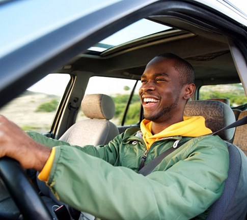 Man smiles while driving