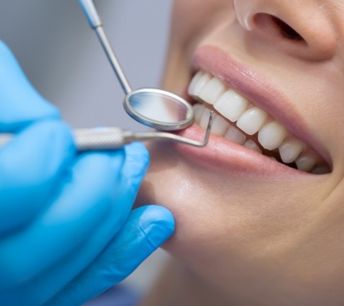 Dentist examining patient's smile after gum recontouring