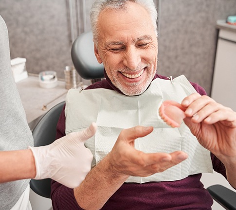 A dentist showing dentures to her patient