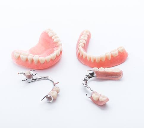 Sets of dentures sitting against a white background