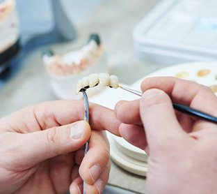 a dental lab technician crafting a dental restoration