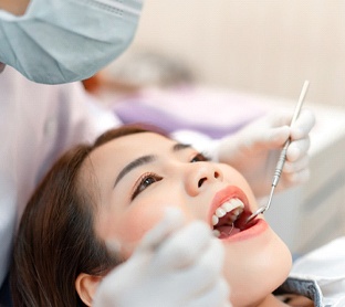 woman at dental checkup for cost of emergency dentistry in Raleigh