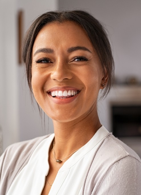 Woman sharing a flawless smile after tooth replacement with dental implants