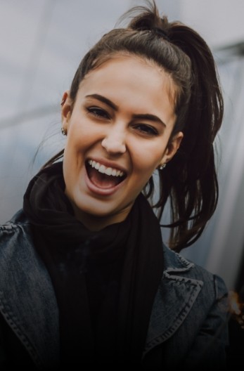 Grinning woman with ponytail wearing black scarf
