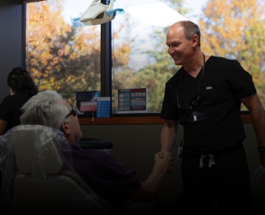 Dentist in Raleigh shaking hands with dental patient