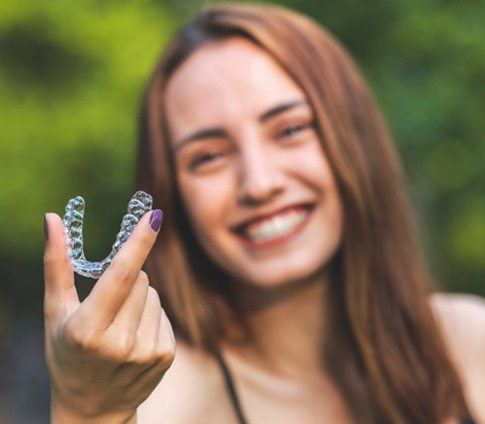 woman taking out Invisalign in Raleigh   