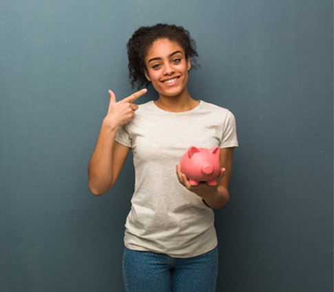 piggy bank woman smiling for cost of Invisalign Raleigh  