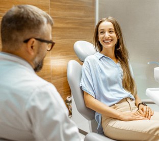 woman meeting with dentist for cost of Invisalign in Raleigh 