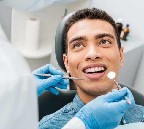 Man receiving dental checkup and teeth cleaning