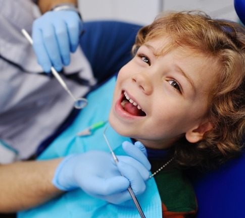 Child receiving dental checkup and teeth cleaning for kids