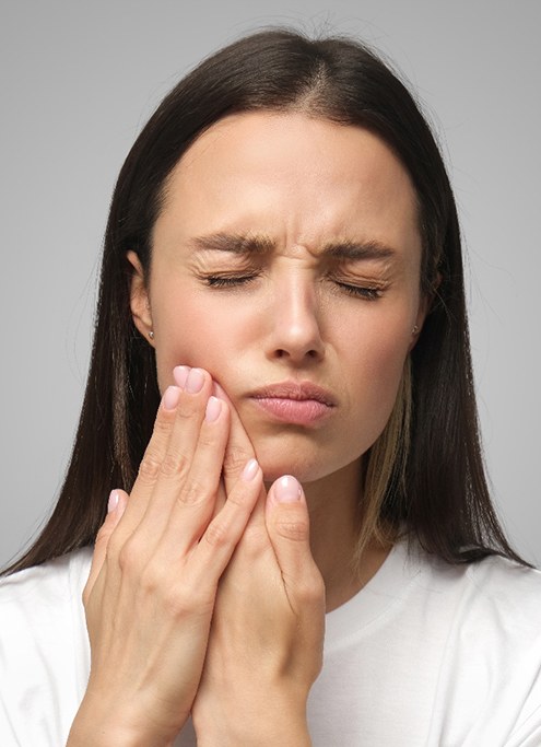 Woman with oral pain rubbing her jaw