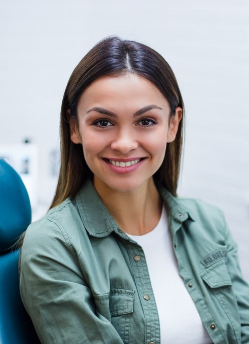 Woman smiling after receiving dental services