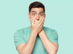 Man covering his mouth after his losing a veneer
