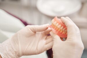 Person holding a pair of dentures